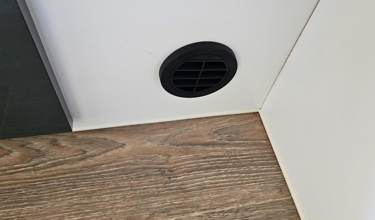 Heater outlet cut into the internal wall of caravan.